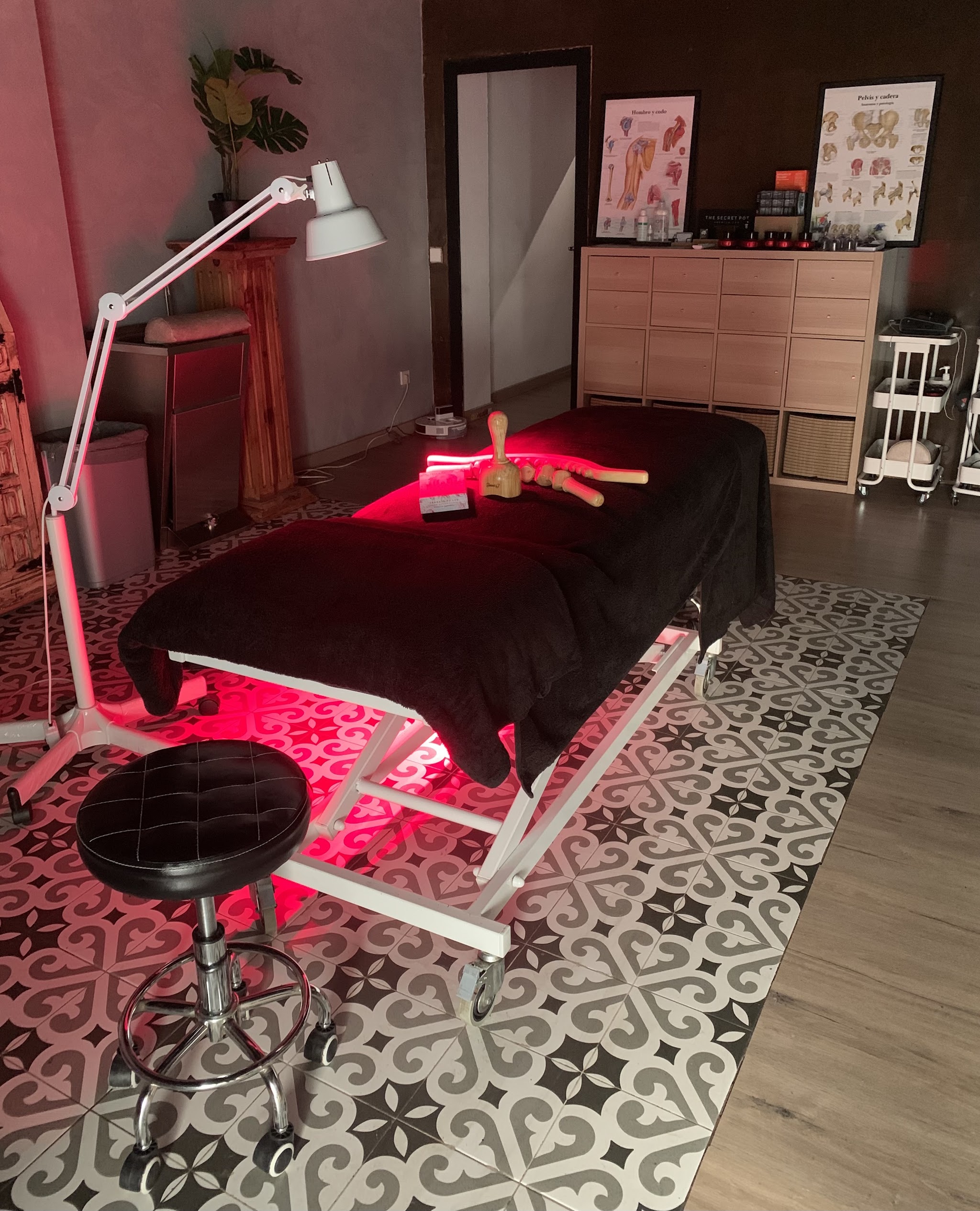 Behandeltafel met zwarte doek onder rood infraroodlicht, met houten tools op de tafel